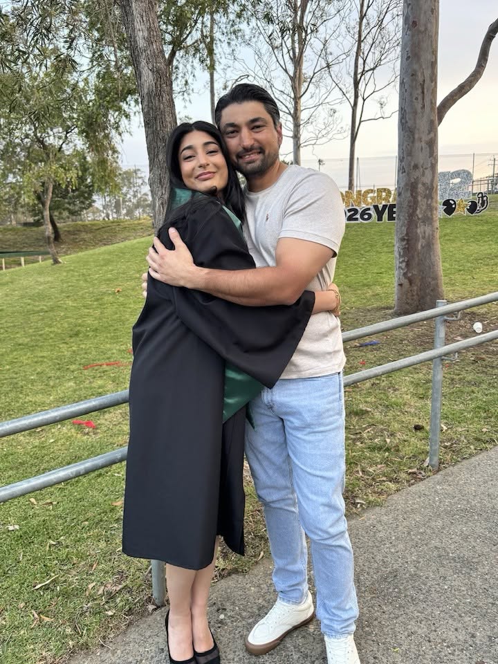 Angelina in her graduation gown hugging her father Yousif