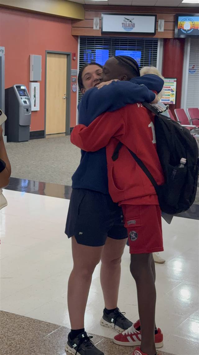 Amber and Kervenson embrace at the airport